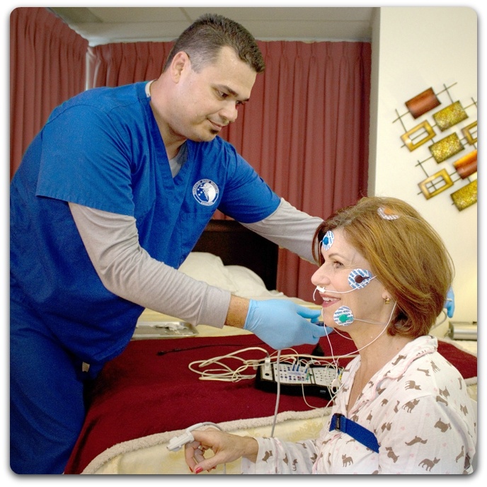 Sleep study technician putting sensors on patient